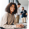 image of women smiling while working on laptop